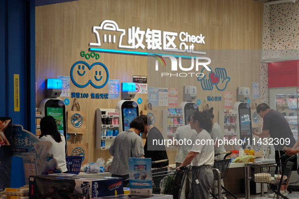 Customers are shopping at a Freshippo store in the Huangpu district of Shanghai, China, on July 25, 2024. 