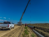 Workers are installing fiberglass tubes in a high-standard farmland in Karamay, China, on July 24, 2024. (