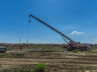 Workers are installing fiberglass tubes in a high-standard farmland in Karamay, China, on July 24, 2024. (