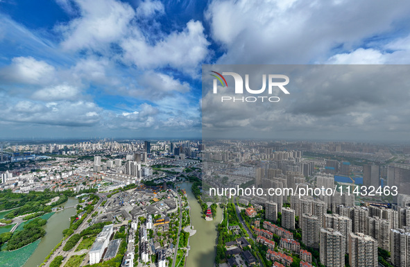 An aerial photo is showing urban buildings under the blue sky and white clouds in Huai'an City, East China's Jiangsu province, on July 25, 2...