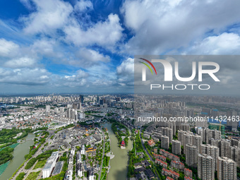 An aerial photo is showing urban buildings under the blue sky and white clouds in Huai'an City, East China's Jiangsu province, on July 25, 2...