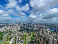 An aerial photo is showing urban buildings under the blue sky and white clouds in Huai'an City, East China's Jiangsu province, on July 25, 2...