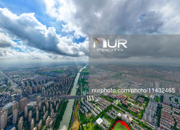 An aerial photo is showing urban buildings under the blue sky and white clouds in Huai'an City, East China's Jiangsu province, on July 25, 2...