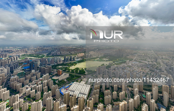 An aerial photo is showing urban buildings under the blue sky and white clouds in Huai'an City, East China's Jiangsu province, on July 25, 2...