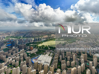 An aerial photo is showing urban buildings under the blue sky and white clouds in Huai'an City, East China's Jiangsu province, on July 25, 2...