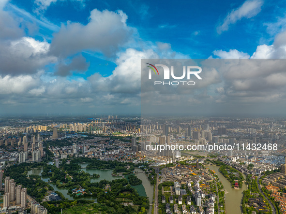 An aerial photo is showing urban buildings under the blue sky and white clouds in Huai'an City, East China's Jiangsu province, on July 25, 2...