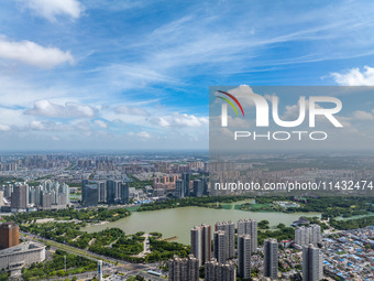 An aerial photo is showing urban buildings under the blue sky and white clouds in Huai'an City, East China's Jiangsu province, on July 25, 2...