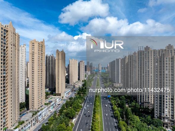 An aerial photo is showing urban buildings under the blue sky and white clouds in Huai'an City, East China's Jiangsu province, on July 25, 2...