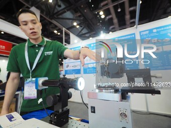 A staff member is demonstrating a ''bare fiber grinder'' at the ''Fifth World Photonic Congress 2024'' in Beijing, China, on July 25, 2024....