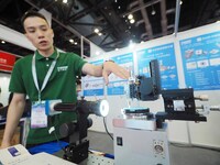 A staff member is demonstrating a ''bare fiber grinder'' at the ''Fifth World Photonic Congress 2024'' in Beijing, China, on July 25, 2024....