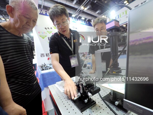 Visitors are visiting the ''Six-axis core tuning System'' at the ''Fifth World Photonics Congress 2024'' in Beijing, China, on July 25, 2024...