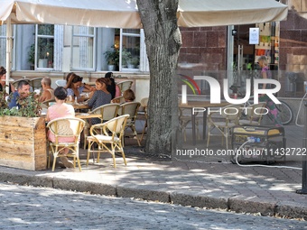 A diesel generator is being used as a backup during power outages near an outdoor cafe in Odesa, Ukraine, on July 23, 2024. NO USE RUSSIA. N...