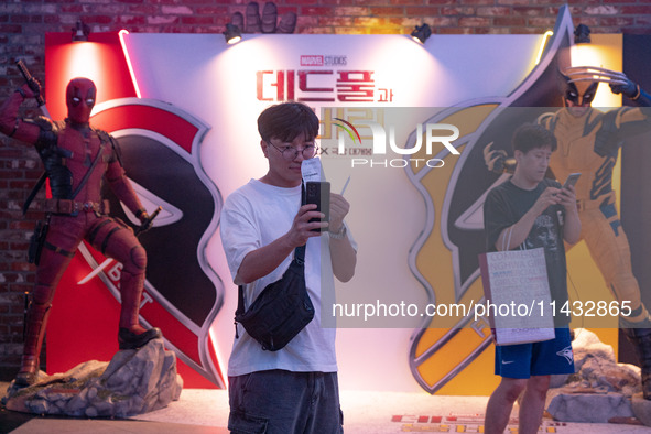 A man is taking a selfie with his movie ticket in front of a billboard of Marvel Studios movie 'Deadpool & Wolverine' in Seoul, South Korea,...