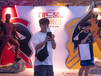 A man is taking a selfie with his movie ticket in front of a billboard of Marvel Studios movie 'Deadpool & Wolverine' in Seoul, South Korea,...