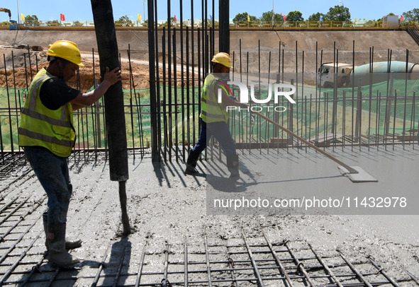 Construction workers are pouring concrete on the middle slab (platform floor) of the Changbei Airport Station of the Beijing-Hong Kong high-...