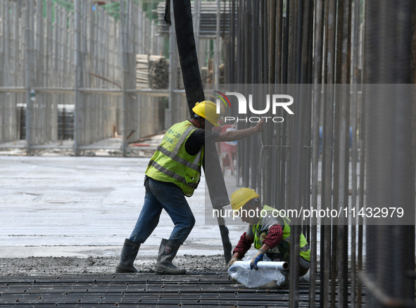 Construction workers are pouring concrete on the middle slab (platform floor) of the Changbei Airport Station of the Beijing-Hong Kong high-...