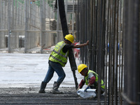 Construction workers are pouring concrete on the middle slab (platform floor) of the Changbei Airport Station of the Beijing-Hong Kong high-...