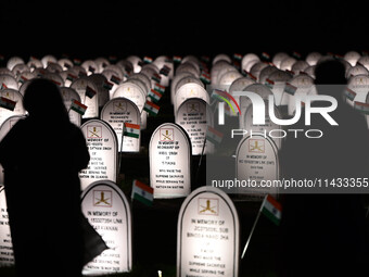 People are standing next to the war memorial during the ''Vijay Diwas'' or Victory Day celebration in Drass, Jammu and Kashmir, on July 25,...