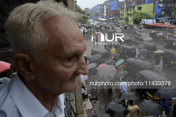 People are carrying umbrellas while going to their workplace during rainfall in Mumbai, India, on July 25, 2024. 