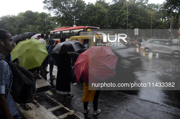 People are carrying umbrellas during rainfall in Mumbai, India, on July 25, 2024. 