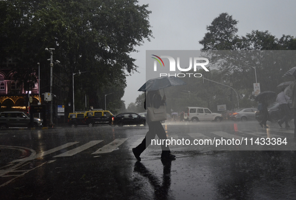 People are carrying umbrellas during rainfall in Mumbai, India, on July 25, 2024. 