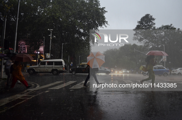 People are carrying umbrellas during rainfall in Mumbai, India, on July 25, 2024. 