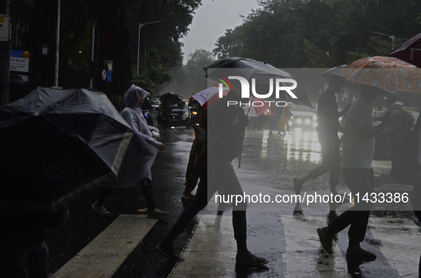 People are carrying umbrellas during rainfall in Mumbai, India, on July 25, 2024. 