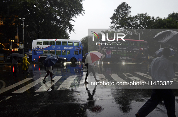 People are carrying umbrellas during rainfall in Mumbai, India, on July 25, 2024. 