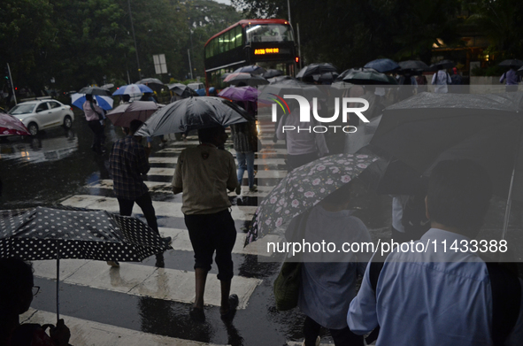 People are carrying umbrellas during rainfall in Mumbai, India, on July 25, 2024. 