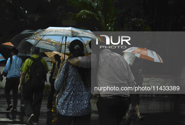 People are carrying umbrellas during rainfall in Mumbai, India, on July 25, 2024. 