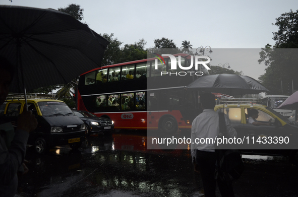 People are carrying umbrellas during rainfall in Mumbai, India, on July 25, 2024. 