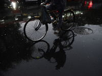 A reflection of a cyclist is being seen on a wet road during rainfall in Mumbai, India, on July 25, 2024. (