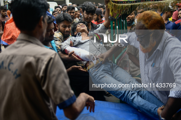 An injured protester is being brought to the Dhaka Medical College Hospital for emergency medical treatment in Dhaka, Bangladesh, on Saturda...