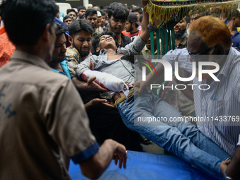 An injured protester is being brought to the Dhaka Medical College Hospital for emergency medical treatment in Dhaka, Bangladesh, on Saturda...