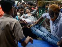 An injured protester is being brought to the Dhaka Medical College Hospital for emergency medical treatment in Dhaka, Bangladesh, on Saturda...