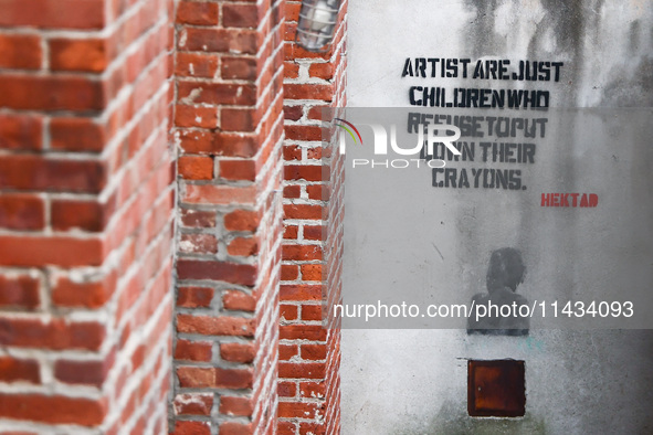 'Artists are just children who refuse to put down their crayins'  writing by Hektad i seen on a wall in Dumbo area in Brooklyn, New York in...