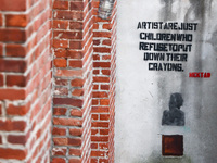 'Artists are just children who refuse to put down their crayins'  writing by Hektad i seen on a wall in Dumbo area in Brooklyn, New York in...