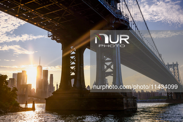  A view on Manhattan Bridge and Manhattan sklyline during sunset over the East River in New York City, United States of America on July 7th,...