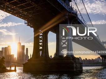  A view on Manhattan Bridge and Manhattan sklyline during sunset over the East River in New York City, United States of America on July 7th,...