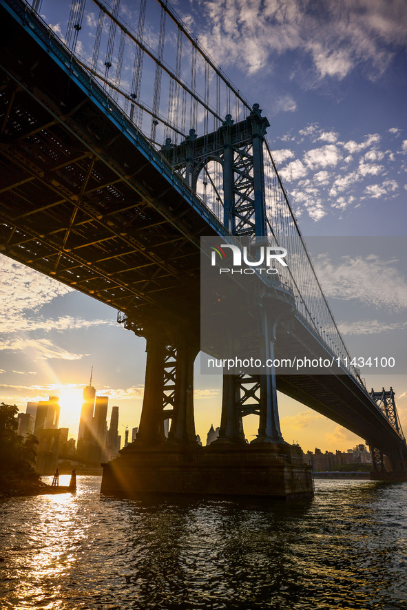  A view on Manhattan Bridge and Manhattan sklyline during sunset over the East River in New York City, United States of America on July 7th,...