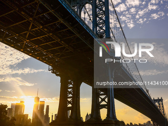  A view on Manhattan Bridge and Manhattan sklyline during sunset over the East River in New York City, United States of America on July 7th,...