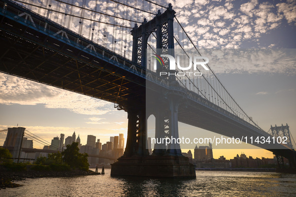  A view on Manhattan Bridge and Manhattan sklyline during sunset over the East River in New York City, United States of America on July 7th,...