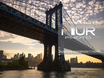  A view on Manhattan Bridge and Manhattan sklyline during sunset over the East River in New York City, United States of America on July 7th,...