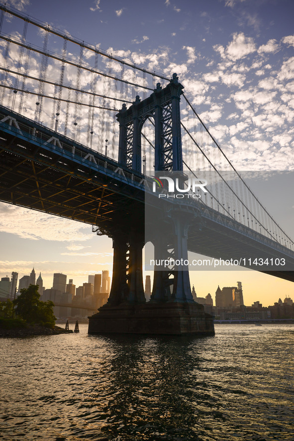  A view on Manhattan Bridge and Manhattan sklyline during sunset over the East River in New York City, United States of America on July 7th,...