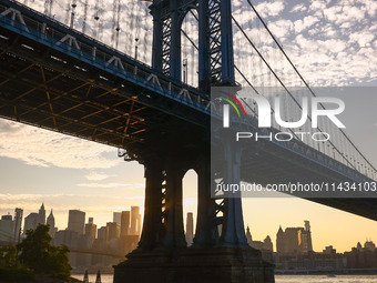  A view on Manhattan Bridge and Manhattan sklyline during sunset over the East River in New York City, United States of America on July 7th,...