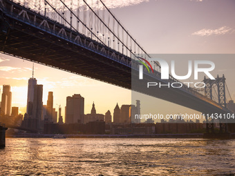  A view on Manhattan Bridge and Manhattan sklyline during sunset over the East River in New York City, United States of America on July 7th,...