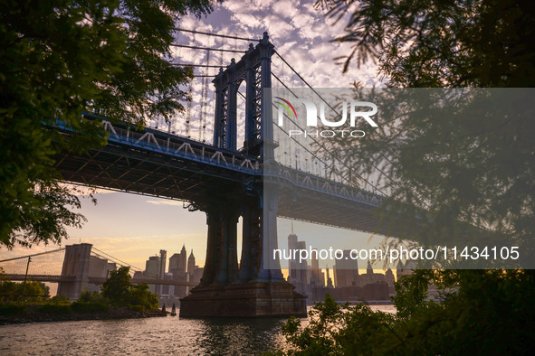  A view on Manhattan Bridge and Manhattan sklyline during sunset over the East River in New York City, United States of America on July 7th,...