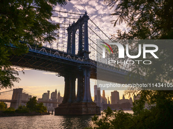  A view on Manhattan Bridge and Manhattan sklyline during sunset over the East River in New York City, United States of America on July 7th,...