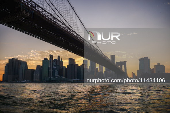  A view on Manhattan Bridge and Manhattan sklyline during sunset over the East River in New York City, United States of America on July 7th,...