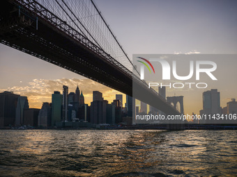  A view on Manhattan Bridge and Manhattan sklyline during sunset over the East River in New York City, United States of America on July 7th,...